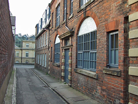 Brick building with stone detailing, on narrow lane