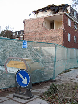 Part-demolished building behind barriers