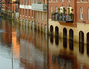 Riverside buildings reflected in water