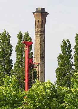 Victorian chimney, through trees, red construction machinery alongside