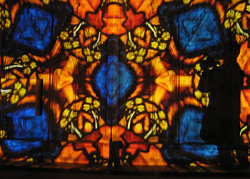 Light projections on cathedral stone wall giving stained glass effect