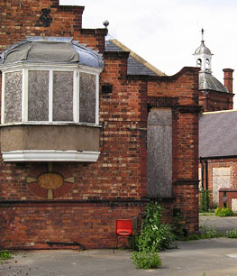 Victorian red brick school building, with boarded-up windows