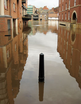 Flood water reflecting buildings in street