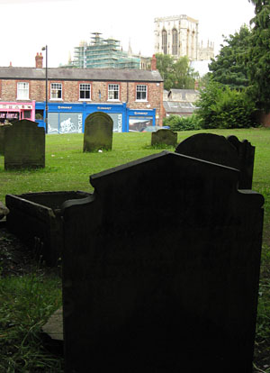 View towards city wall and Minster. Headstones in foreground